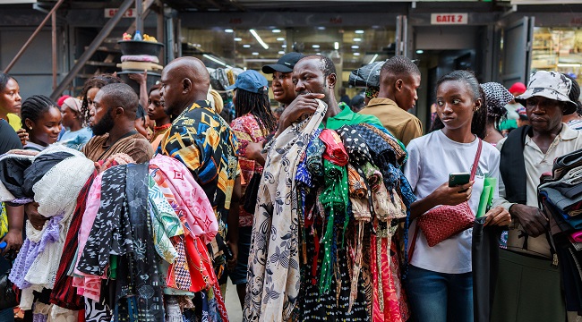 A-man-waits-for-costumers-while-selling-clothes-at-the-Balogun-Market-in-Lagos-on-December-18-2023-2